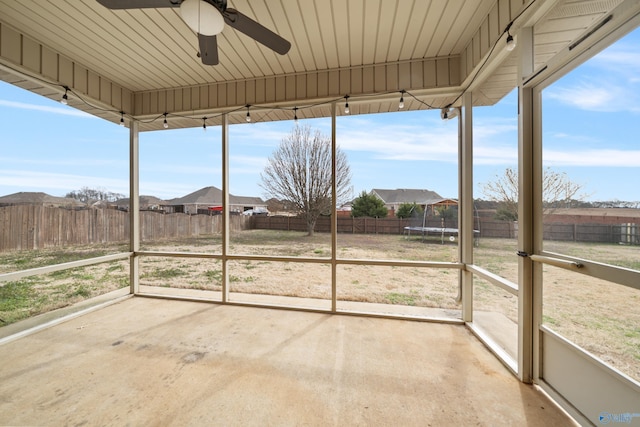 unfurnished sunroom with ceiling fan