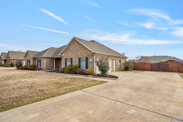 ranch-style home featuring a garage, brick siding, fence, driveway, and a front yard