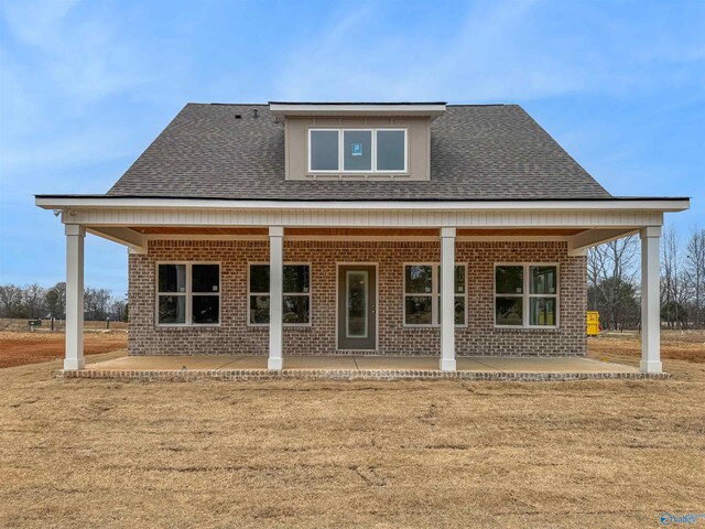 rear view of property featuring a yard and a patio area