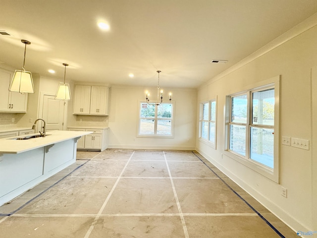 kitchen with tasteful backsplash, light countertops, white cabinetry, a sink, and baseboards