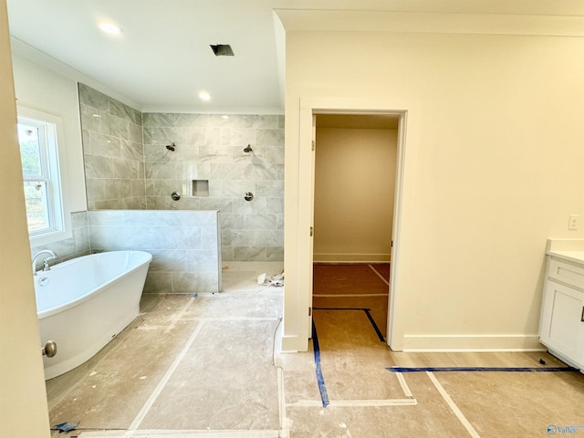 bathroom featuring baseboards, a soaking tub, walk in shower, vanity, and recessed lighting