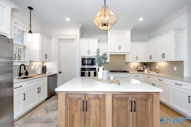 kitchen featuring white cabinets, appliances with stainless steel finishes, tasteful backsplash, and sink