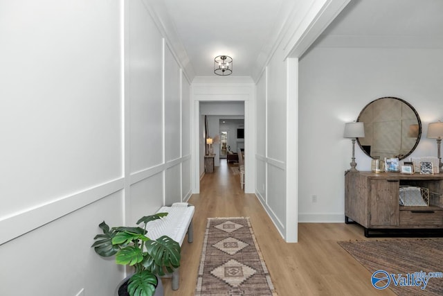 corridor featuring light hardwood / wood-style floors and crown molding