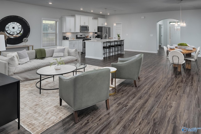 living room with dark wood-type flooring and a notable chandelier