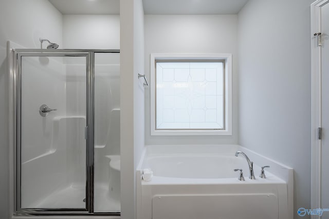 bathroom featuring shower with separate bathtub