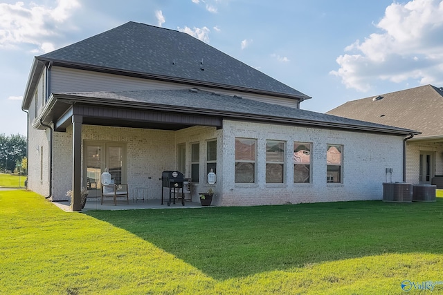 rear view of property with a yard, central AC, and a patio