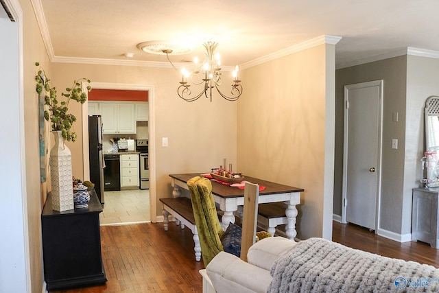 dining room featuring dark wood-type flooring, ornamental molding, and an inviting chandelier