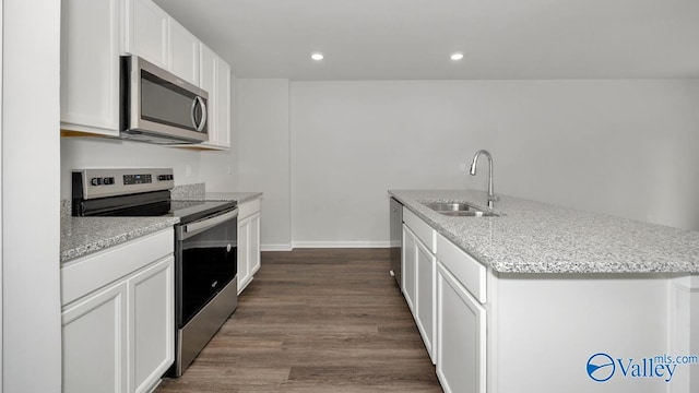 123 Trestle Point Dr, Harvest, AL 35749 - kitchen featuring appliances with stainless steel finishes, a sink, a center island with sink, dark wood-style floors, and white cabinets