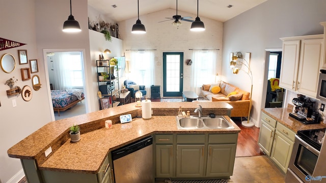 kitchen with appliances with stainless steel finishes, pendant lighting, high vaulted ceiling, sink, and a kitchen island with sink