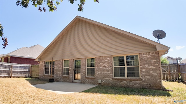 back of house featuring a patio and a yard