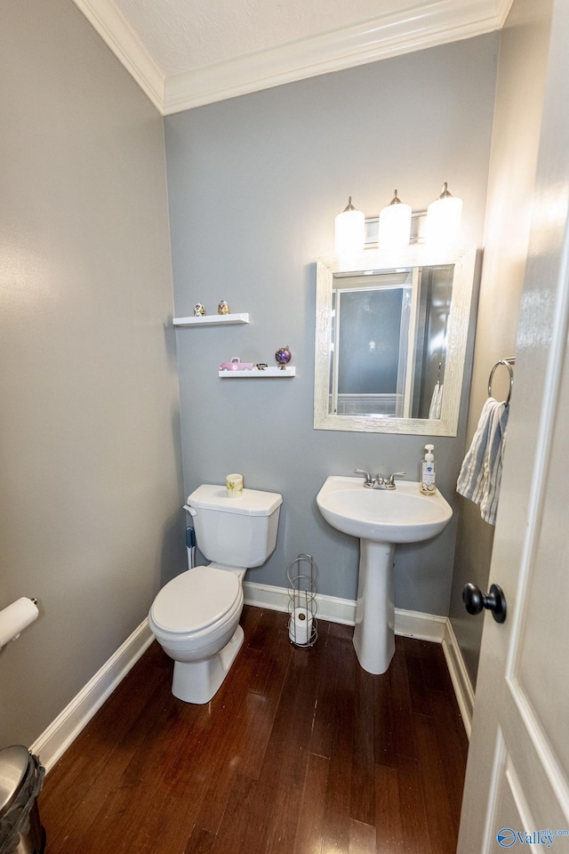 166 Hickory Rdg, Glencoe, AL 35905 - half bathroom featuring wood finished floors, crown molding, baseboards, toilet, and a sink