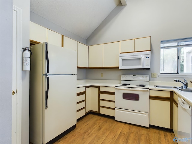 kitchen with light hardwood / wood-style floors, cream cabinets, vaulted ceiling, sink, and white appliances