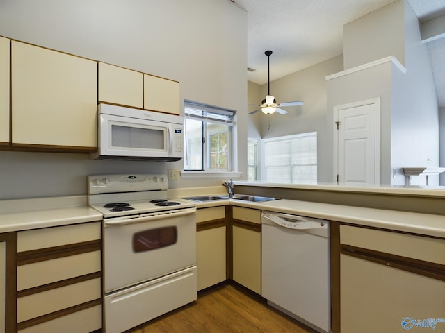 kitchen with kitchen peninsula, sink, ceiling fan, light wood-type flooring, and white appliances