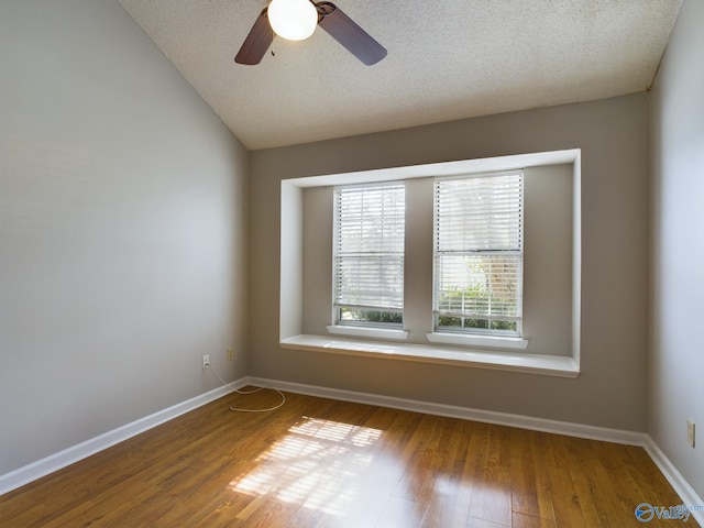 unfurnished room with hardwood / wood-style floors, ceiling fan, a textured ceiling, and vaulted ceiling