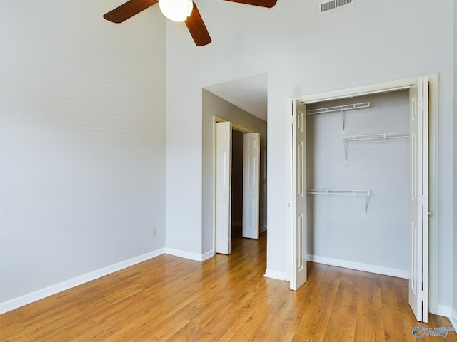 unfurnished bedroom featuring light hardwood / wood-style floors, ceiling fan, and a closet