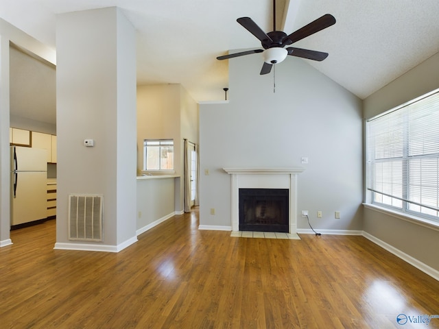 unfurnished living room featuring wood-type flooring, vaulted ceiling, and ceiling fan