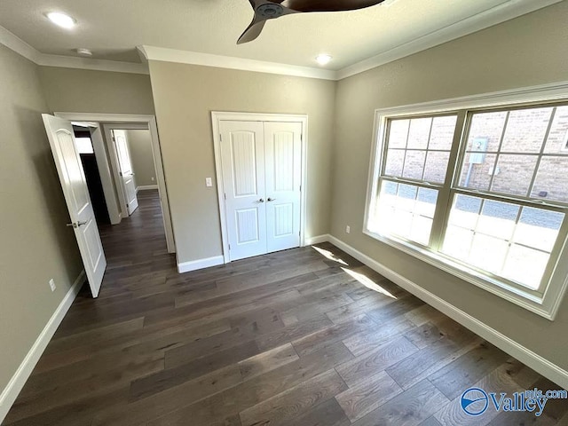 unfurnished bedroom with a ceiling fan, baseboards, ornamental molding, a closet, and dark wood-style floors