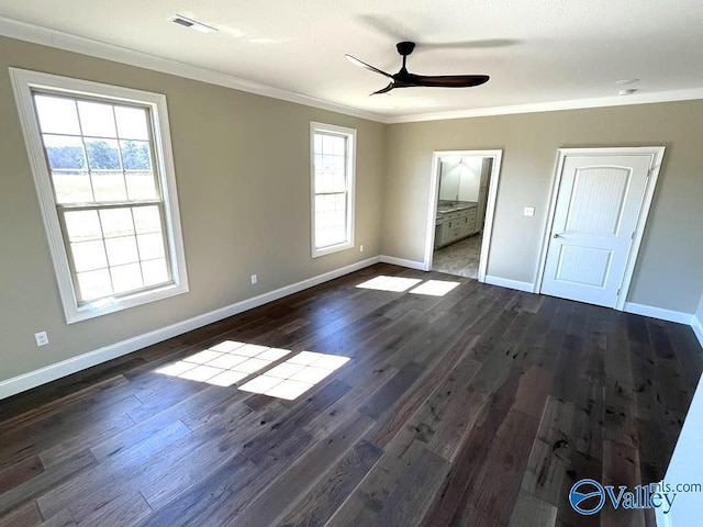 unfurnished bedroom with baseboards, dark wood-type flooring, visible vents, and crown molding