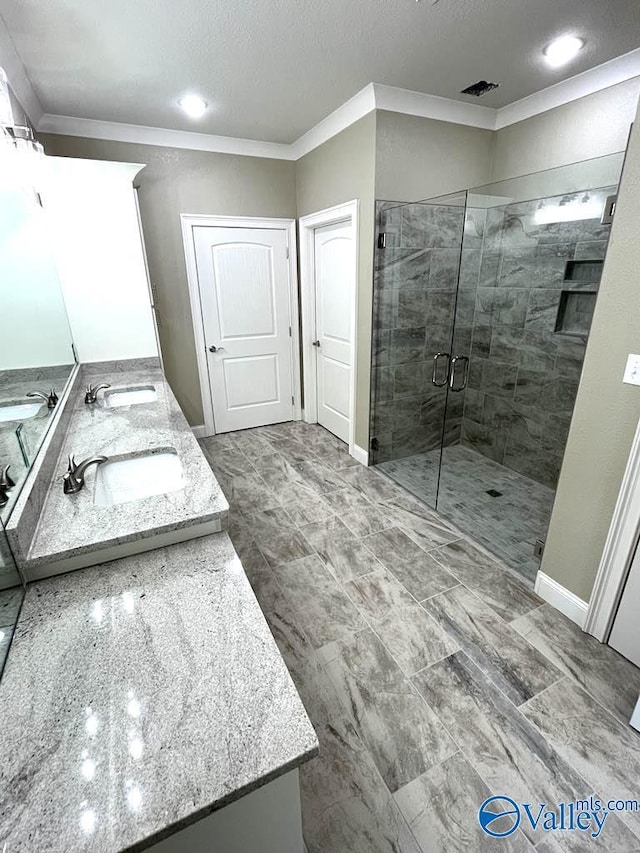 full bath with double vanity, ornamental molding, a sink, and a shower stall