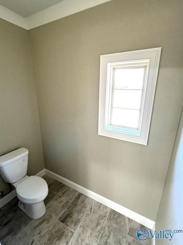 bathroom with toilet and baseboards