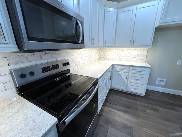 kitchen featuring light countertops, backsplash, appliances with stainless steel finishes, white cabinetry, and baseboards