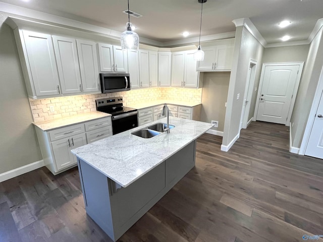 kitchen featuring electric range oven, an island with sink, stainless steel microwave, light stone countertops, and white cabinetry