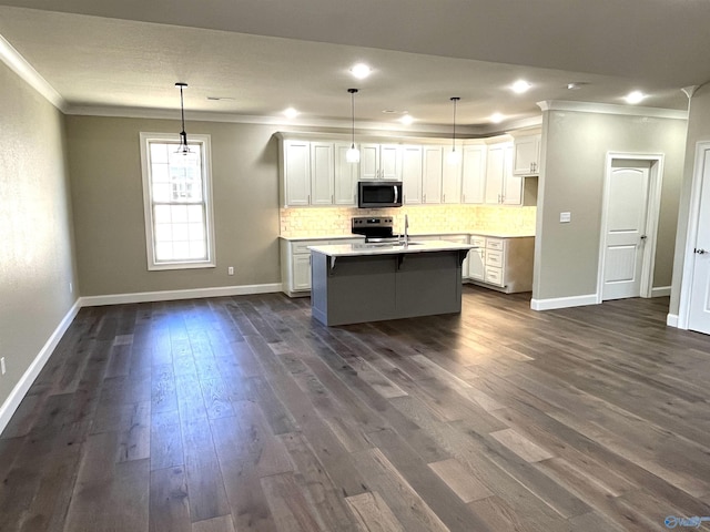 kitchen featuring stainless steel appliances, hanging light fixtures, light countertops, and white cabinets