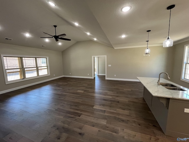 unfurnished living room with baseboards, visible vents, dark wood finished floors, vaulted ceiling, and a sink