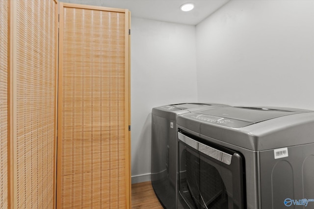 laundry room with separate washer and dryer and hardwood / wood-style floors