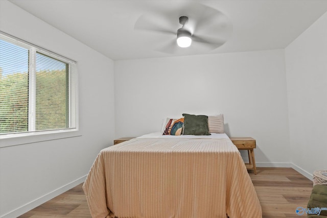 bedroom featuring light hardwood / wood-style flooring, multiple windows, and ceiling fan