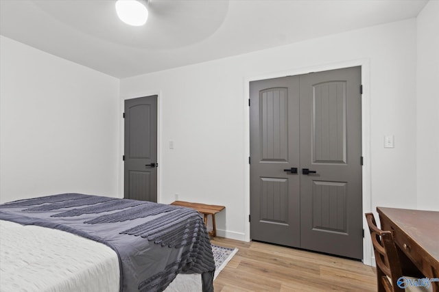 bedroom with a closet, light wood-type flooring, and ceiling fan