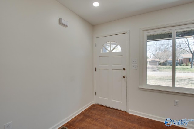 entryway with plenty of natural light, dark wood-type flooring, and baseboards