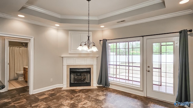 unfurnished living room with crown molding, a tray ceiling, a healthy amount of sunlight, and visible vents