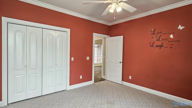unfurnished bedroom featuring crown molding, carpet, baseboards, a ceiling fan, and a closet