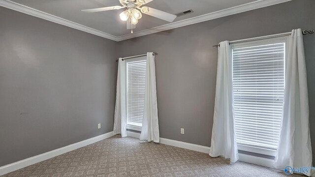 empty room featuring baseboards, crown molding, visible vents, and a ceiling fan