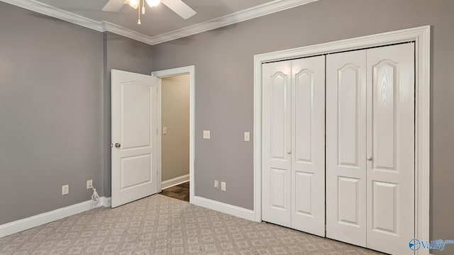unfurnished bedroom with carpet flooring, baseboards, a closet, and ornamental molding