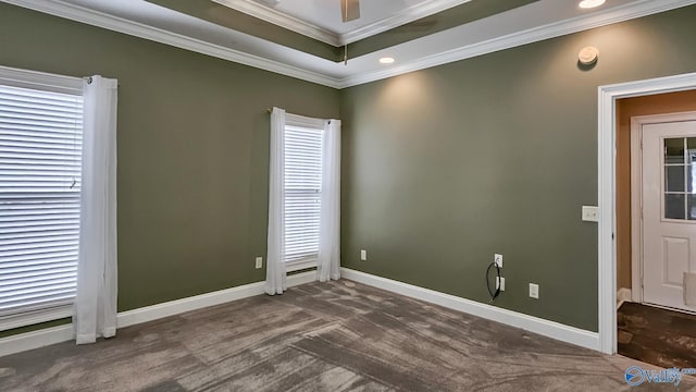 spare room with baseboards, a ceiling fan, crown molding, and dark colored carpet