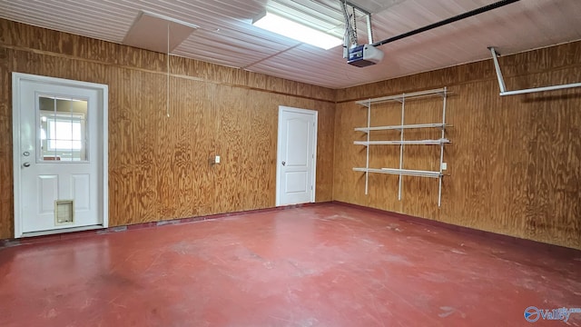 garage with a garage door opener and wooden walls