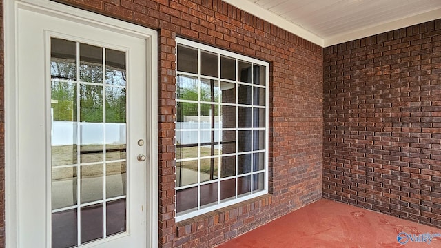 view of exterior entry featuring brick siding