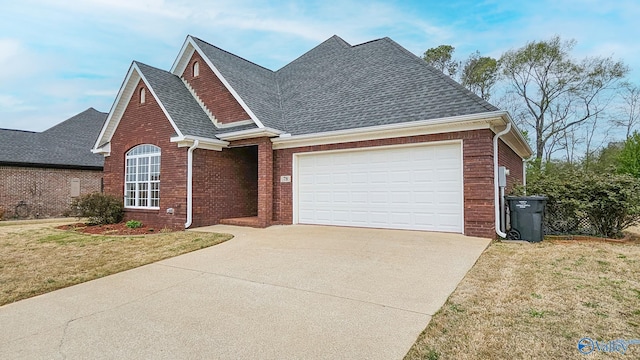 view of front of property featuring a front yard, driveway, a garage, and a shingled roof
