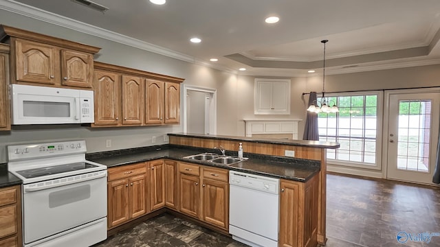 kitchen featuring visible vents, a peninsula, white appliances, ornamental molding, and a sink