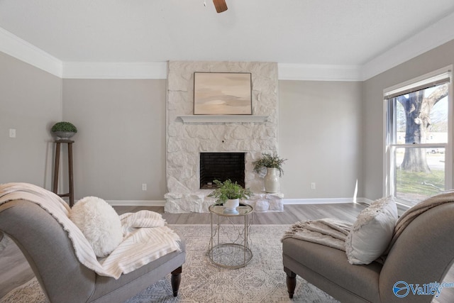 1816 Devonshire Dr SE, Decatur, AL 35601 - living area with baseboards, wood finished floors, a stone fireplace, ceiling fan, and crown molding