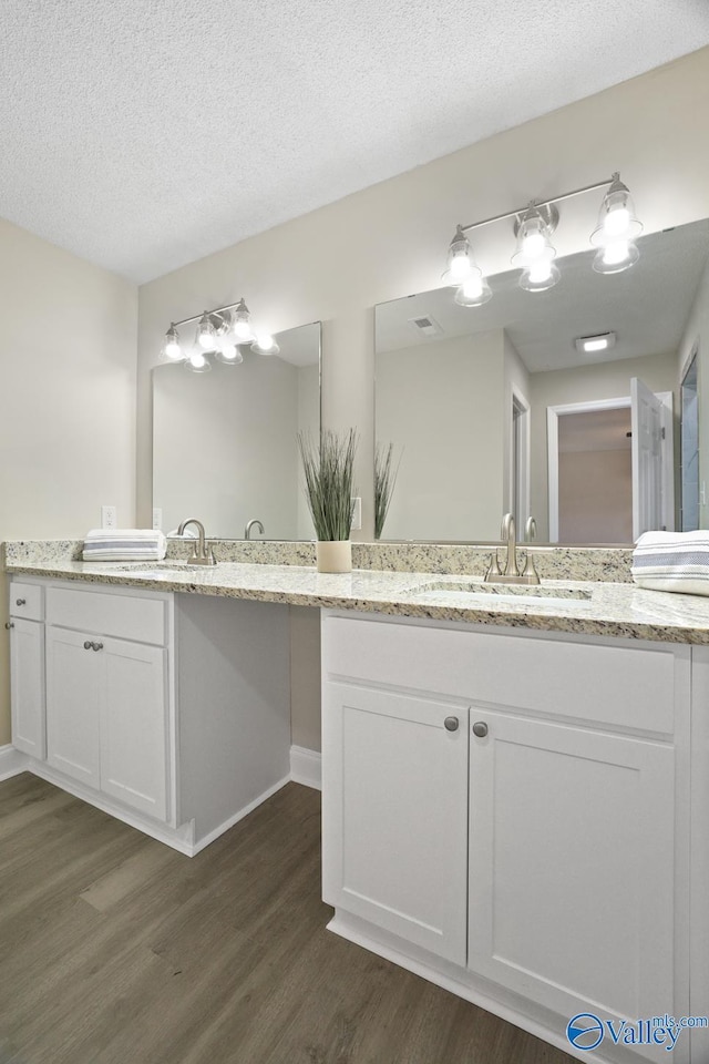 1816 Devonshire Dr SE, Decatur, AL 35601 - full bath with wood finished floors, vanity, a textured ceiling, and baseboards