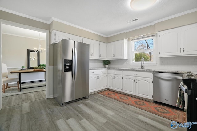 1816 Devonshire Dr SE, Decatur, AL 35601 - kitchen featuring stainless steel appliances, a sink, light wood-type flooring, decorative backsplash, and ornamental molding