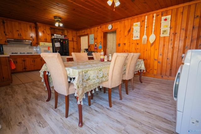 dining area with wood ceiling, washer / dryer, light wood-type flooring, and wooden walls