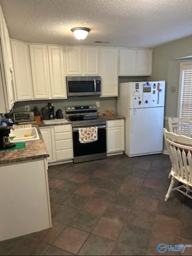 kitchen featuring white cabinetry, sink, stainless steel appliances, and a textured ceiling