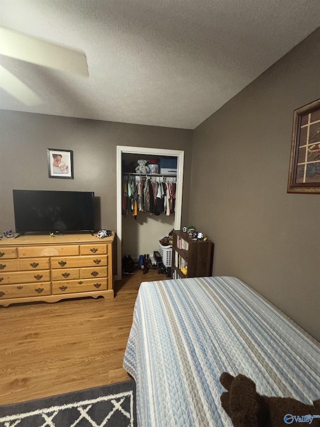 bedroom featuring hardwood / wood-style flooring, a closet, and a textured ceiling