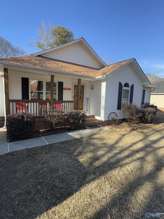 ranch-style house with covered porch and a front lawn