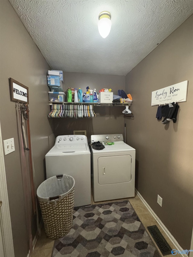 laundry room with separate washer and dryer and a textured ceiling