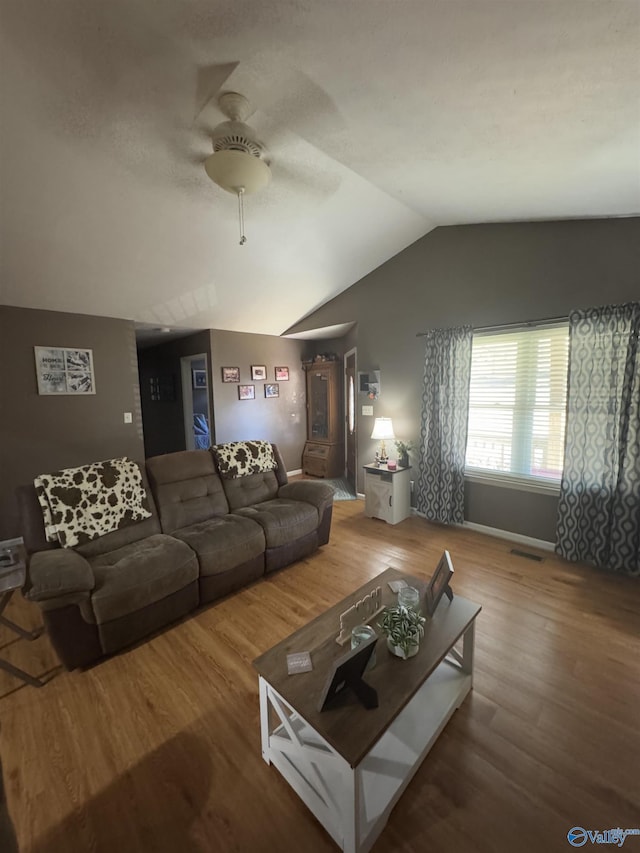 living room featuring lofted ceiling, hardwood / wood-style flooring, and ceiling fan